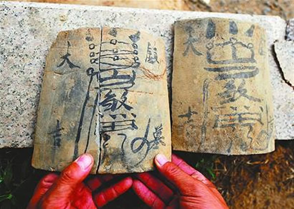 从墓室中发现的写有"镇墓大吉"等字样和图案的瓦片记者今天接到热心